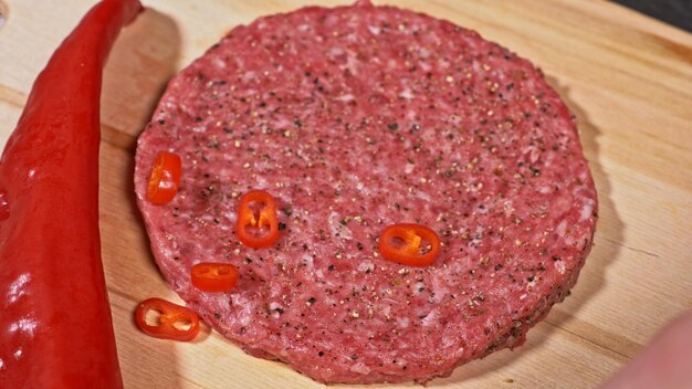 Photo le cuisinier fait des médaillons de viande pour les hamburgers le chef dans des gants de cuisine noirs fait que les côtelettes de côtelettes sont nivelées