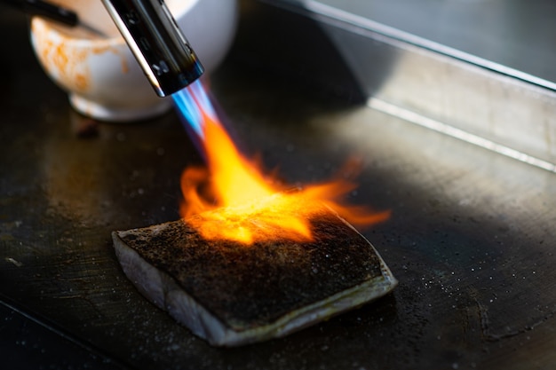 Un cuisinier fume un poisson