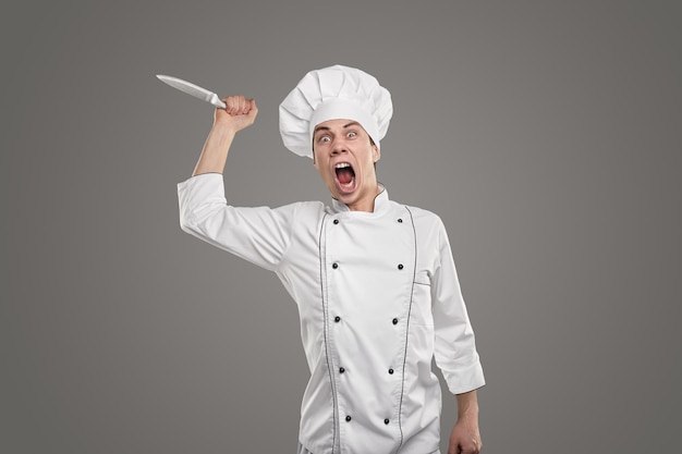 Cuisinier irrité avec un couteau de cuisine criant à la caméra