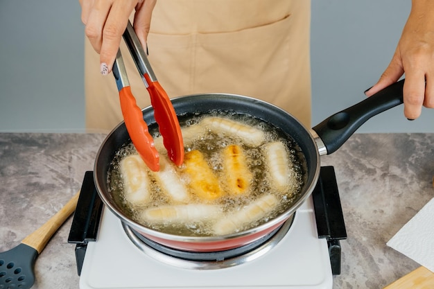 Cuisinier latino-américain préparant et faisant frire l'apéritif latin tequenos vénézuélien