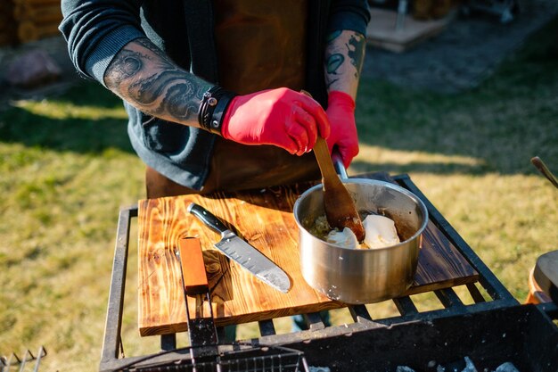 Le cuisinier mélange les aliments dans une casserole Concept de la bonne cuisson de la viande Le chef prépare des frites un steak de boeuf à l'extérieur