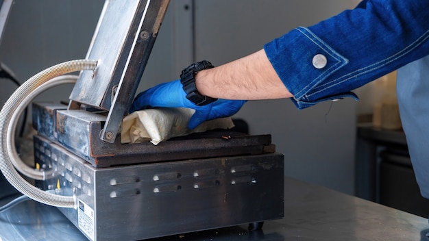 Cuisinier mettant un wrap à cuire dans un food truck