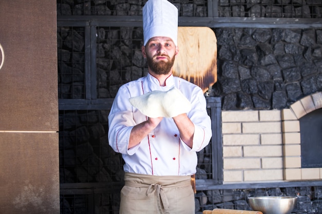 Cuisinier préparant une pizza dans un restaurant.