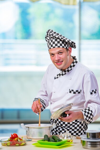 Photo cuisinier préparant un repas dans la cuisine