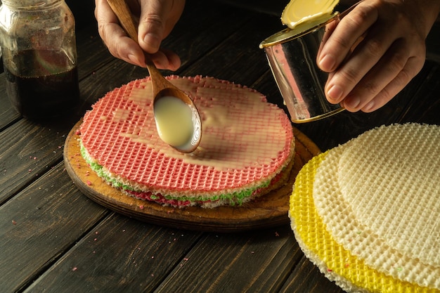 Photo le cuisinier prépare un gâteau à gaufres rond sur la table de la cuisine