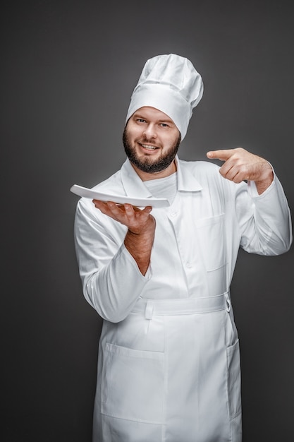 Cuisinier professionnel pointant sur une assiette vide