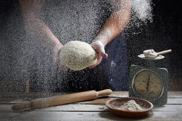 Le cuisinier verse la farine sur le pain