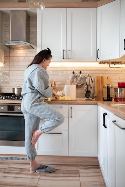 Cuisinière de femme à la cuisine domestique préparant la nourriture