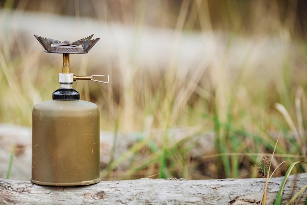 Photo cuisinière à gaz sur bois sur fond de forêt déjeuner pendant le voyage vers le mode de vie de camping sauvage