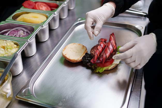 Photo la cuisinière prépare un burger végétalien dans son restaurant