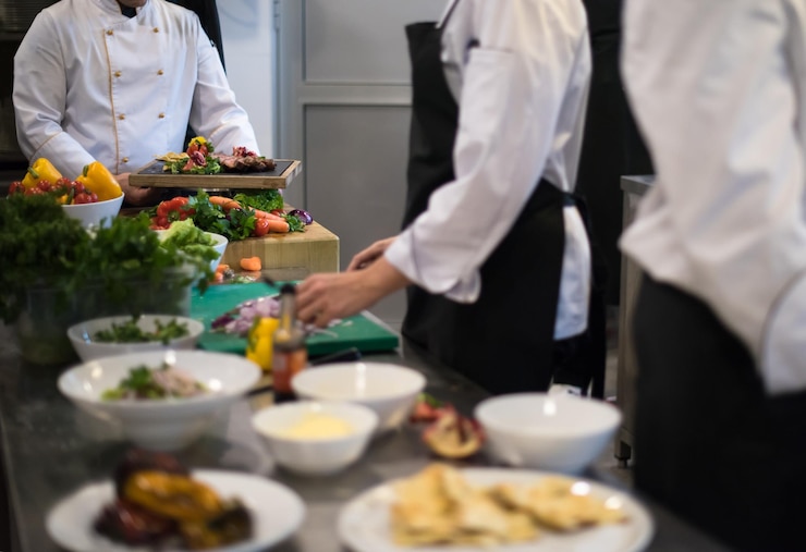 Photo cuisiniers et chefs professionnels de l'équipe préparant le repas dans la cuisine animée d'un hôtel ou d'un restaurant