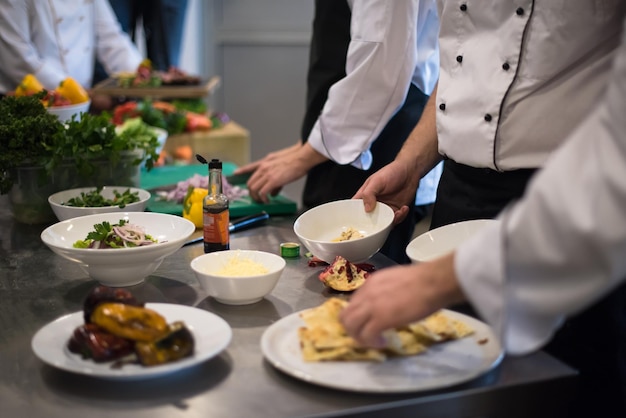 Cuisiniers et chefs professionnels de l'équipe préparant le repas dans la cuisine animée d'un hôtel ou d'un restaurant