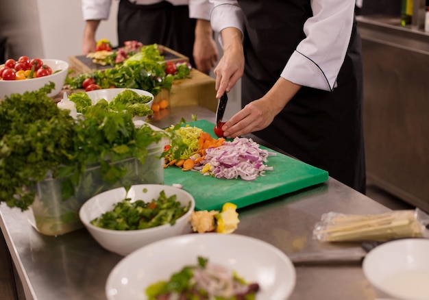 Cuisiniers et chefs professionnels de l'équipe préparant le repas dans la cuisine animée d'un hôtel ou d'un restaurant