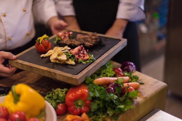 Cuisiniers et chefs professionnels de l'équipe préparant le repas dans la cuisine animée d'un hôtel ou d'un restaurant