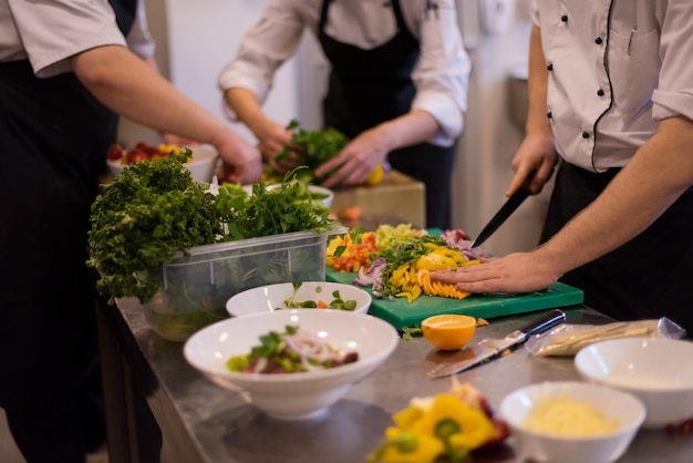 Cuisiniers et chefs professionnels de l'équipe préparant le repas dans la cuisine animée d'un hôtel ou d'un restaurant