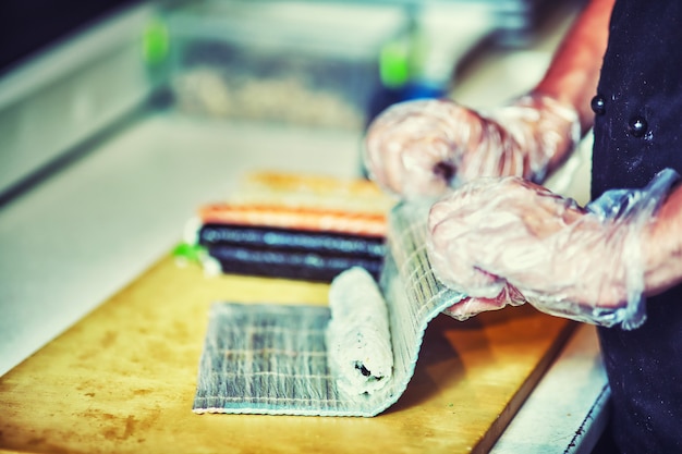 Cuisiniers masculins préparant des sushis dans la cuisine du restaurant.