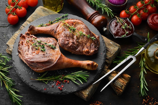 Cuisse de canard au four avec épices et romarin Viande barbecue Vue de dessus Vue de dessus à plat sur la table de coupe en pierre noire