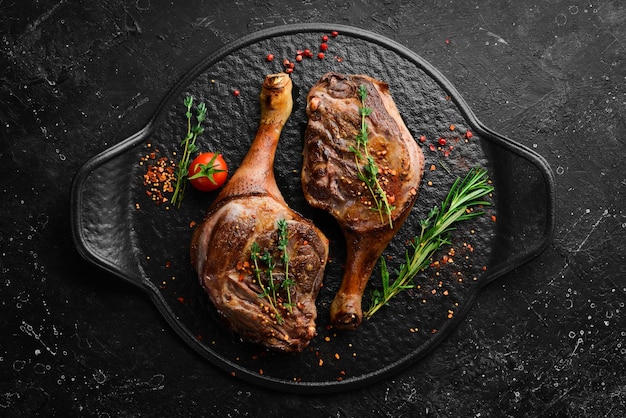 Cuisse de canard au four avec épices et romarin Viande barbecue Vue de dessus Vue de dessus à plat sur la table de coupe en pierre noire