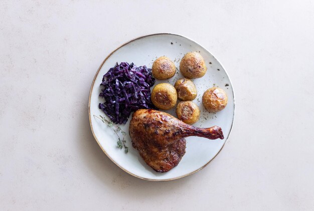 Cuisse de canard au four avec pommes de terre et chou rouge