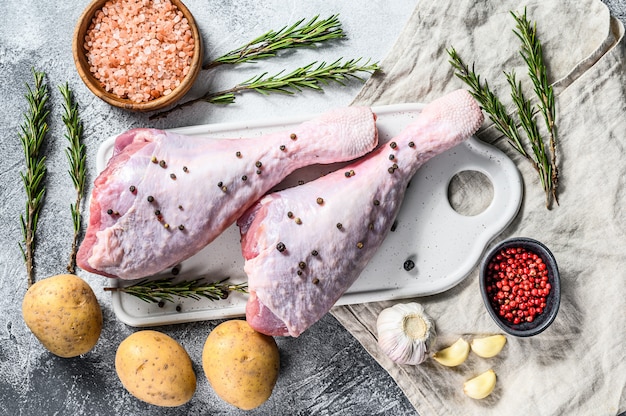 Cuisse de dinde aux épices sur une planche à découper blanche. Fond gris. Vue de dessus