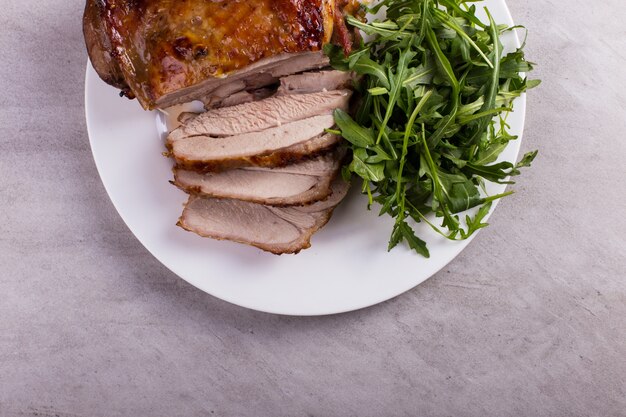 Cuisse de dinde cuite au four avec des épices sur une assiette blanche posée sur la table. La nourriture saine. Dîner de Thanksgiving.