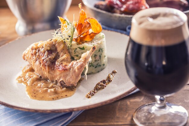 Cuisse de lapin avec purée de pommes de terre et décoration sur assiette au restaurant.