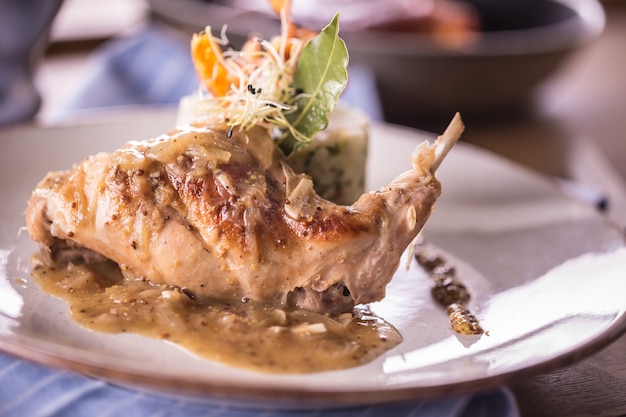 Cuisse de lapin avec purée de pommes de terre et décoration sur assiette au restaurant.