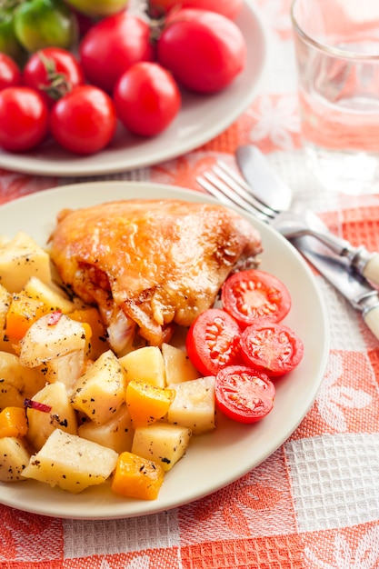 Cuisse de poulet au four avec pommes de terre au four et garniture de citrouille sur une plaque