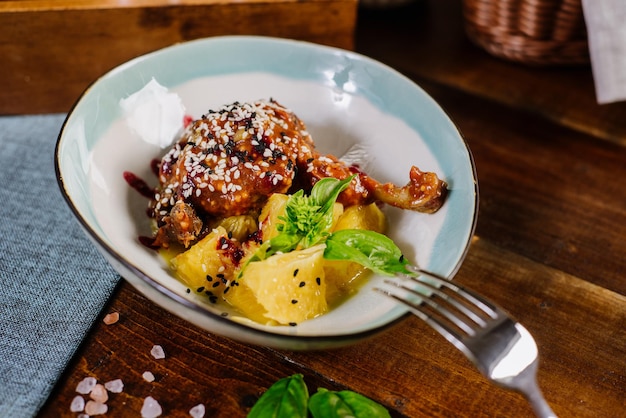 Cuisse de poulet au four avec sauce et fruits sur le fond en bois