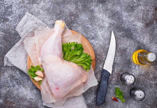 Cuisse de poulet cru sur une planche à découper