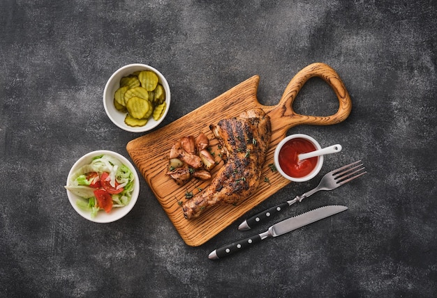 Cuisse de poulet grillée à l'ail et sauce sur une planche de bois Vue d'en haut