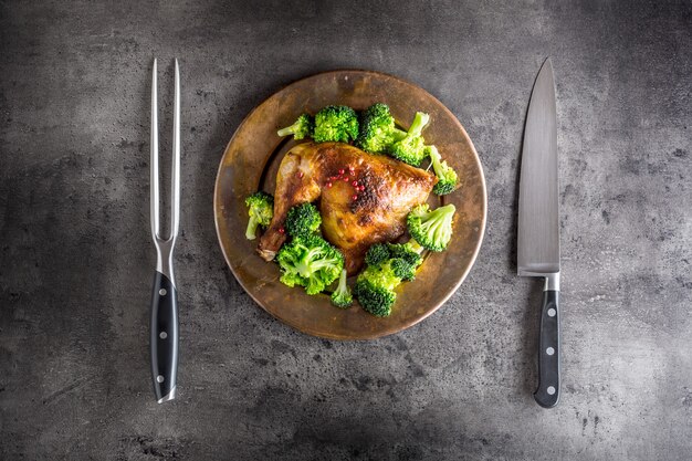 Cuisse de poulet rôti. Cuisse de poulet rôtie au brocoli sur table en béton.