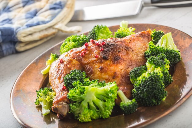 Cuisse de poulet rôti. Cuisse de poulet rôtie avec brocoli sur table.