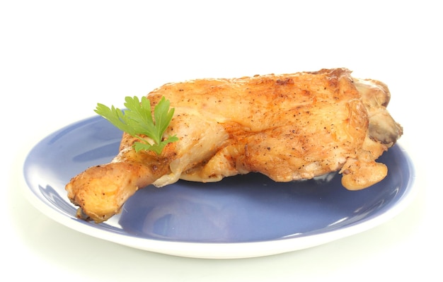 Cuisse de poulet rôtie au persil dans l'assiette isolée sur blanc