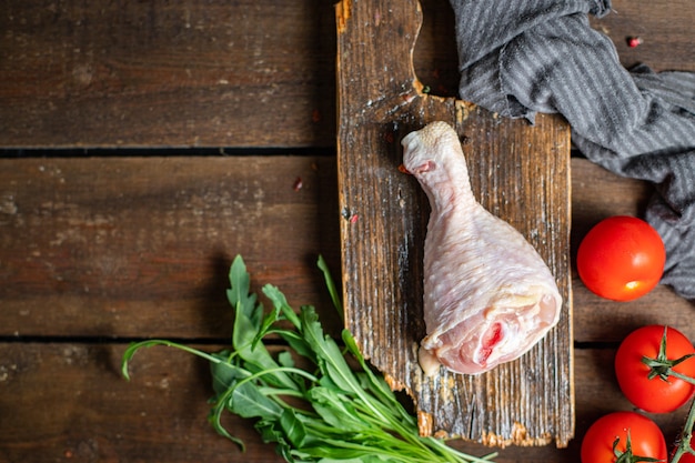 Cuisse de poulet viande crue os de la peau du gril morceau frais prêt à manger sur la table