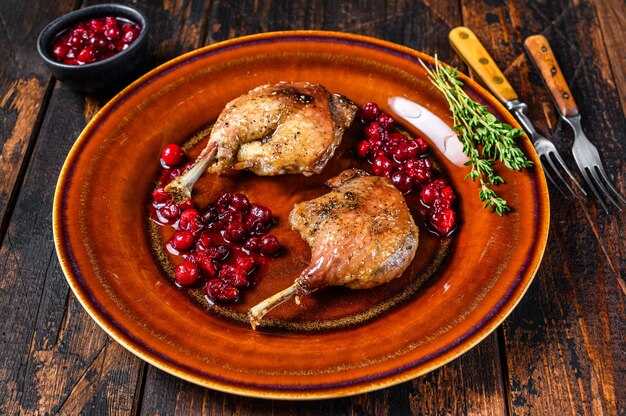 Cuisses De Canard Rôties Avec Sauce Aux Canneberges. Table En Bois Sombre. Vue De Dessus.