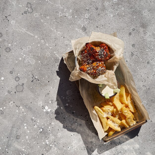 cuisses frites, pilons à la sauce moutarde au miel et pommes de terre frites avec sel et sauce sur pierre