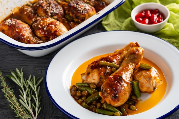 Cuisses de poulet au four avec pois, haricots et herbes fraîches. Pilons de poulet avec une savoureuse sauce et des verts