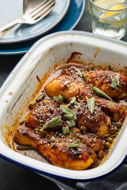 Cuisses de poulet au four avec pois, haricots et herbes fraîches. Pilons de poulet avec une savoureuse sauce et des verts