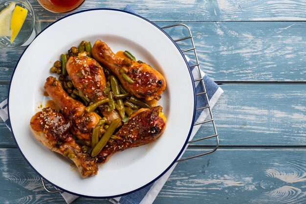 Cuisses de poulet au four avec pois, haricots et herbes fraîches. Pilons de poulet avec une savoureuse sauce et des verts