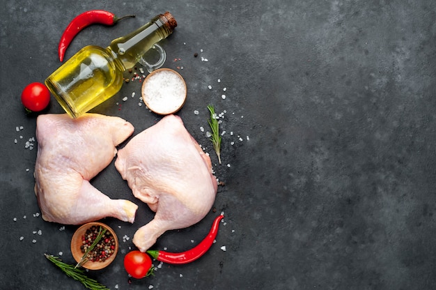 cuisses de poulet aux épices, tomates, huile de tournesol sur un fond de pierre avec copie espace pour votre texte