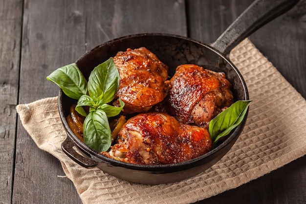 Cuisses de poulet et basilic dans une poêle en fer noir