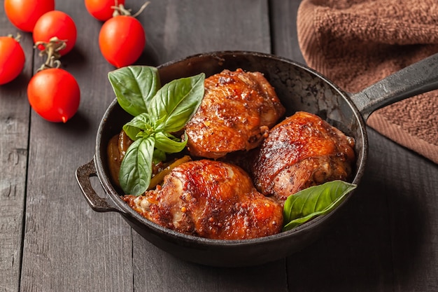 Cuisses de poulet et basilic dans une poêle en fer noir