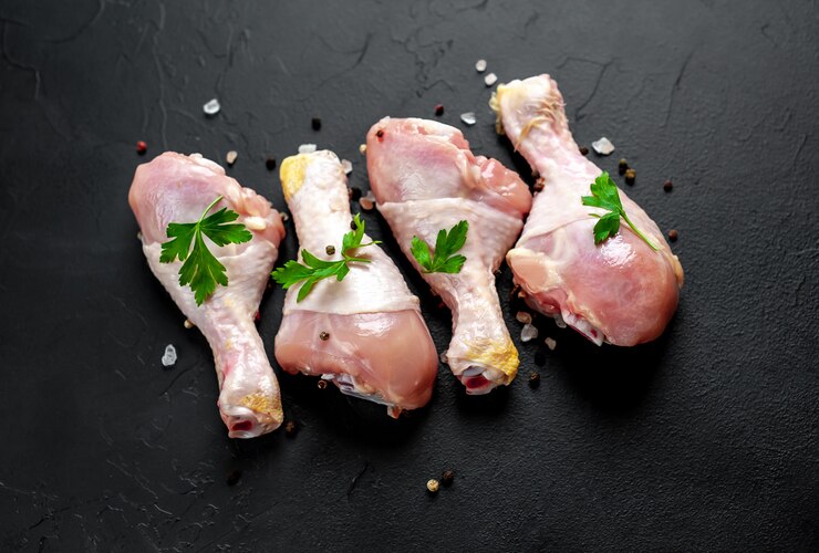 Photo cuisses de poulet cru aux épices sur fond de pierre