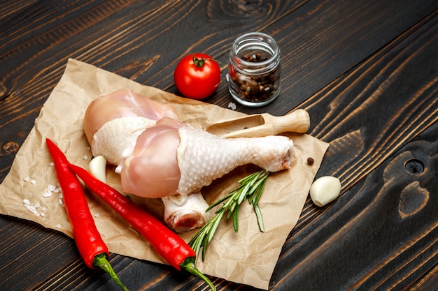 Cuisses de poulet cru dans un plat allant au four sur une table en bois