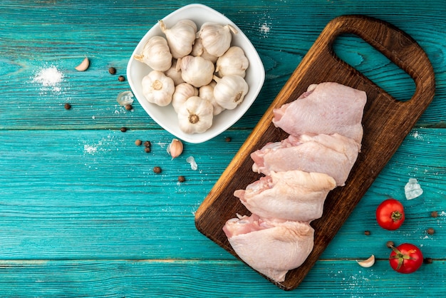 Cuisses de poulet cru sur fond en bois bleu.