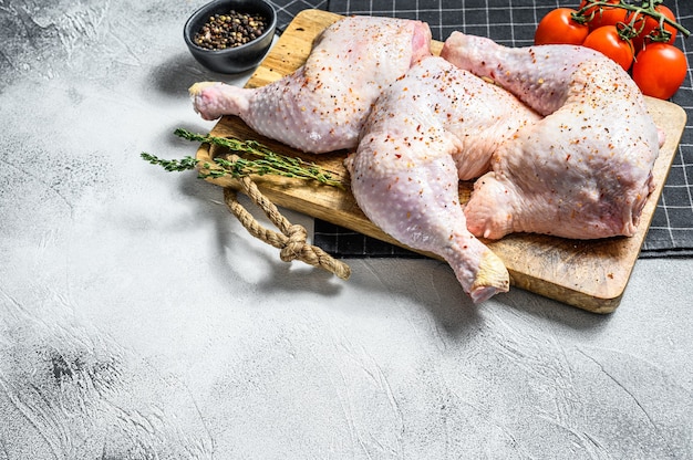 Cuisses de poulet cru frais sur planche de bois