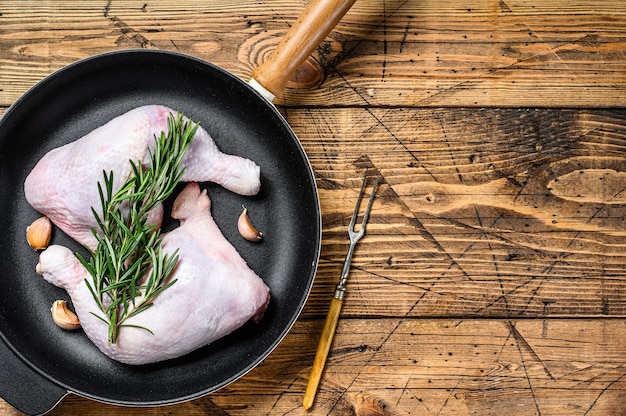 Cuisses de poulet crues dans une poêle prête pour le gril