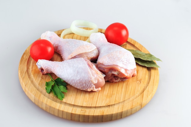 Cuisses de poulet crues sur fond blanc