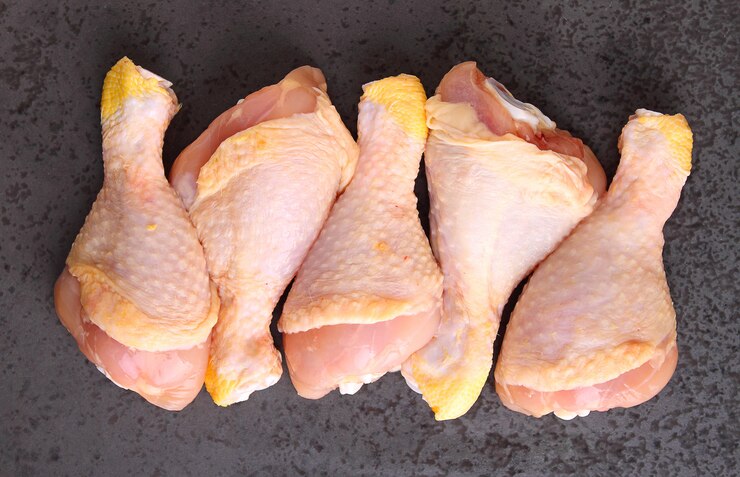 Cuisses de poulet crues sur fond noir